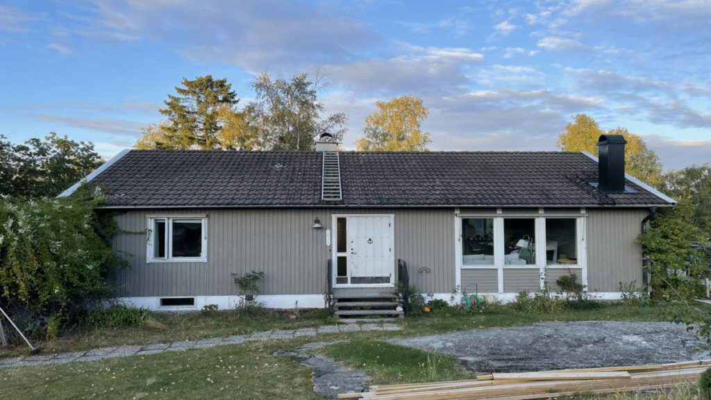 Fasadbyte 70-talshus med grå träpanel som behöver renovering