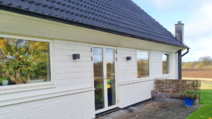 Fasadbyte 70-talshus med vit horisontell träpanel och nya fönster