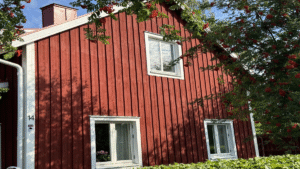 Färdigt resultat efter att kombinera fasadbyte med tilläggsisolering på rött trähus